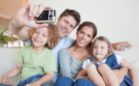 Happy family taking a photo of themselves in their living room
