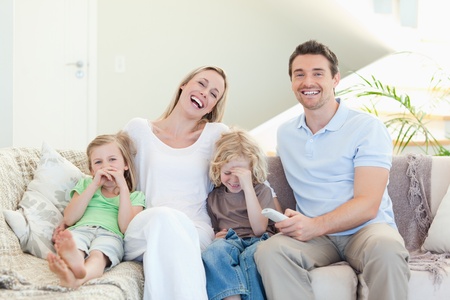 Family laughing on the sofa togetherの写真素材