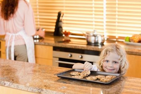 boy stealing a cookie while is mother is not watchingの写真素材