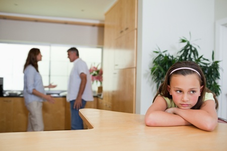 Sad girl listening to her fighting parentsの写真素材