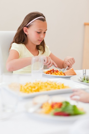 Girl eating at the dinner tableの写真素材