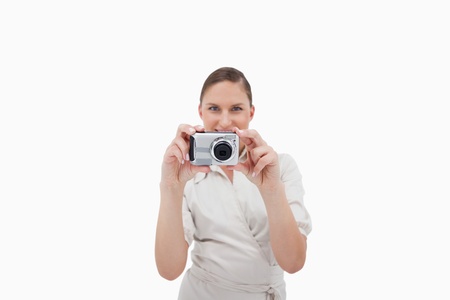 Smiling businesswoman taking a picture against a white background