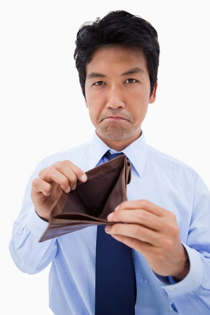 Portrait of a businessman showing his empty wallet against a white background