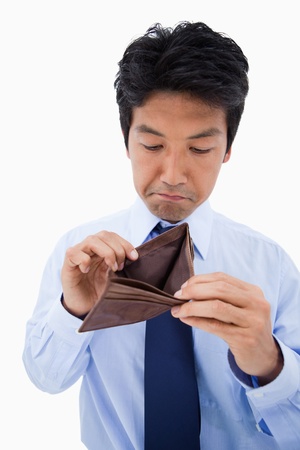 Portrait of a sad businessman showing his empty wallet against a white backgroundの写真素材