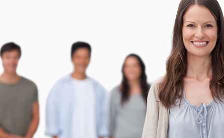 Smiling woman with her friends standing behind her against a white backgroundの写真素材