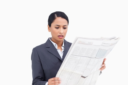 Close up of saleswoman reading news paper against a white backgroundの写真素材