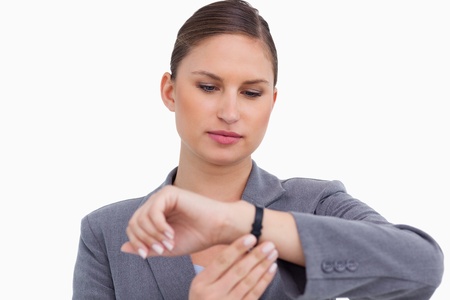 Businesswoman checking her watch against a white backgroundの写真素材