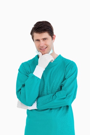 Close up of male doctor wearing scrubs in thinkers pose against a white backgroundの写真素材