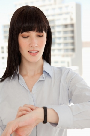 A close up shot of a woman looking at the time on her watch の写真素材