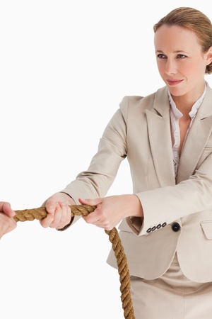 Businesswoman pulling a rope against white backgroundの写真素材