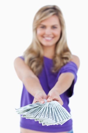 Fan of bank notes being held by a blonde woman against a white backgroundの写真素材