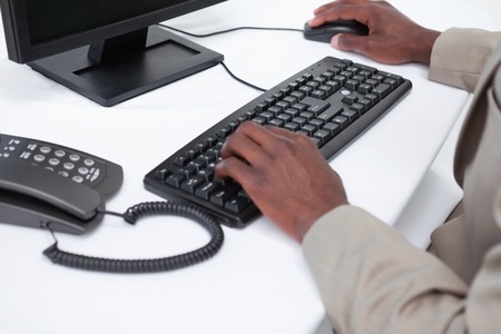 Close up of masculine hands using a computer against a white background