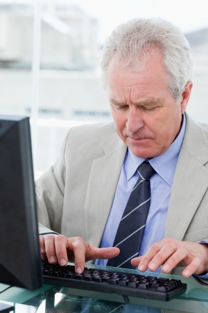 Portrait of a senior manager using a computer in his officeの写真素材