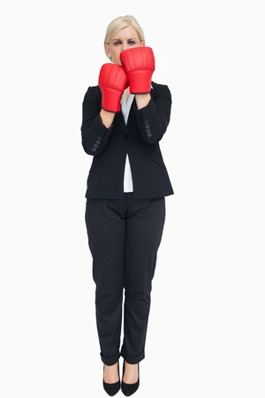 Blonde businesswoman with red gloves against white backgroundの写真素材