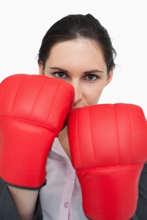 Serious brunette wearing red gloves against white backgroundの写真素材