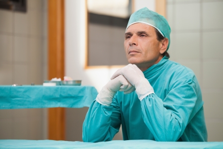Thoughtful surgeon sitting in a operating theater in a hospitalの写真素材
