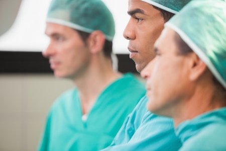 Three surgeons thinking in operating theatre