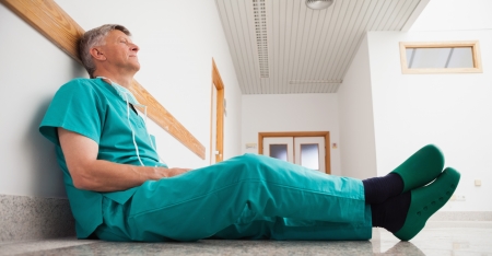Doctor sitting on the floor of hospital corridor