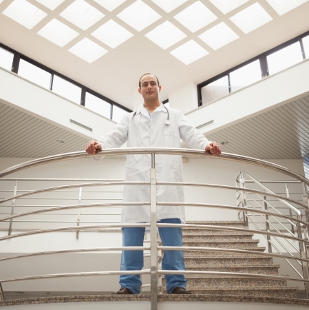 Doctor looking down from stairwell in hospitalの写真素材