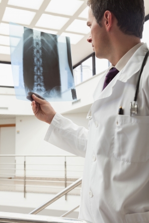 Doctor looking at x-ray in hospital stairwellの写真素材