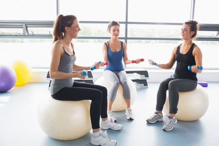 Women doing work out on exercise balls in a gym