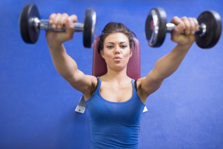 Black-haired woman energetically lifting weightsの写真素材