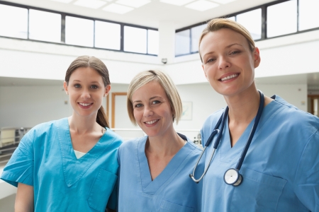 Three happy nurses at hospital stairwellの写真素材