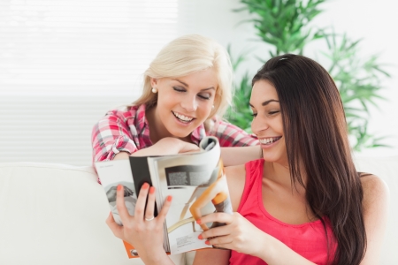 Women looking at the catalog in the house smiling の写真素材