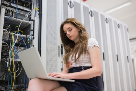 Woman saving data while sitting in the hallwayの写真素材