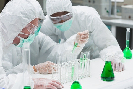 Two chemists experimenting with the green liquid in the laboratory Two chemists experimenting with the green liquid in the laboratory