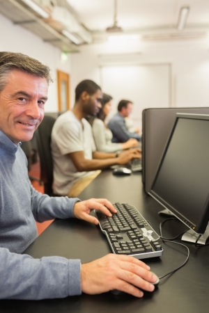 Smiling man working with the computer in classの写真素材