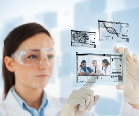 Woman selecting medical images from hologram interface on blue backgroundの写真素材