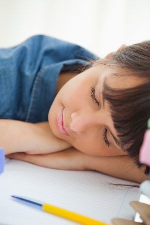 Close-up of a female student sleeping among her books on her deskの写真素材