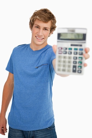 Smiling young man showing a calculator against white backgroundの写真素材