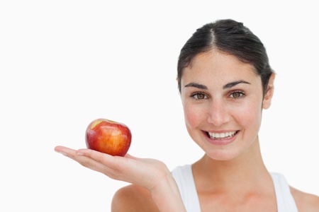 Woman on diet with an apple in the hand against white backgroundの写真素材