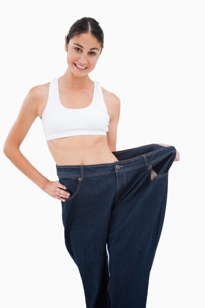 Young woman has lost a lot of weight against white backgroundの写真素材