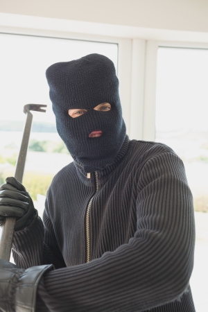 Robber holding a crowbar in his hands while he is inide of the houseの写真素材