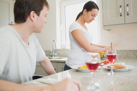 Wife preparing lunch for husband at home in kitchenの写真素材