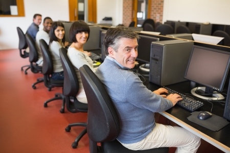Computer class smiling in collegeの写真素材
