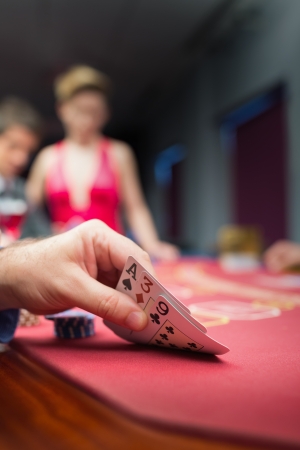 Man lifting poker hand in casinoの写真素材