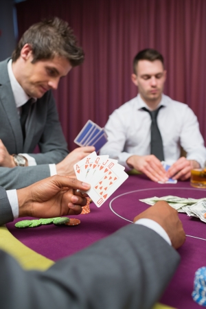 Man at poker table has royal flush in poker game in casinoの写真素材