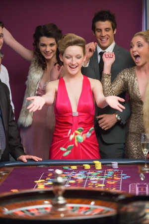 Woman winning at roulette table in casinoの写真素材