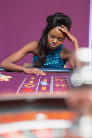 Woman looking upset at roulette table in casinoの写真素材