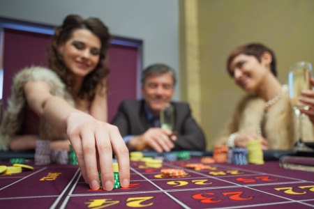 Woman is placing a bet in roulette in casinoの写真素材
