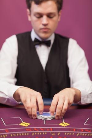 Dealer shuffling the deck of cards at poker tableの写真素材