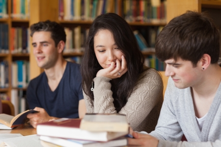 Students studying together in college libraryの写真素材