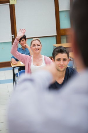 Woman asking question in classroom in collegeの写真素材