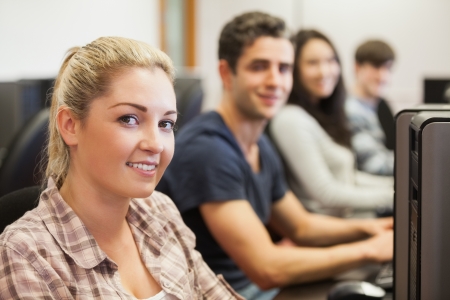 Students sitting at the computer room smiling 