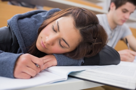 Woman leaning at the desk at the lecture hall dozingの写真素材