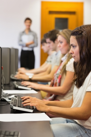 Student sitting at the computer concentrating and typing in college computer classの写真素材